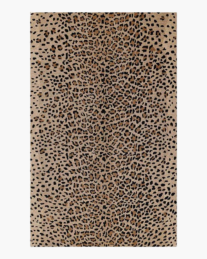 Animal print rug with irregular black markings across a sandy beige and warm brown background.