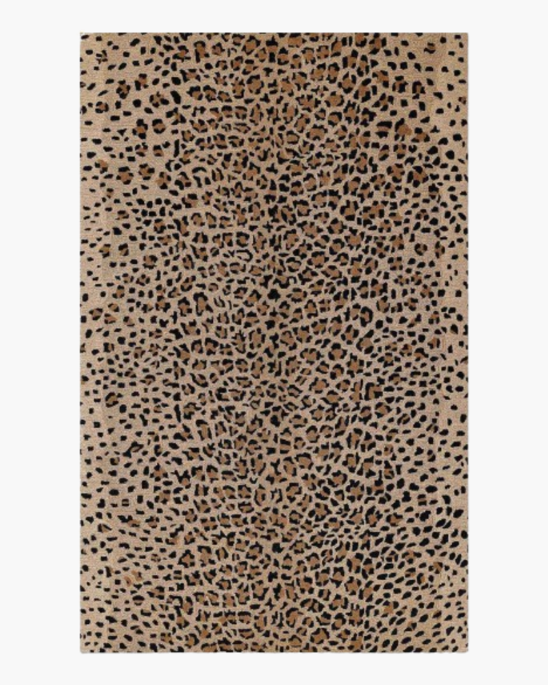 1 Animal print rug with irregular black markings across a sandy beige and warm brown background.